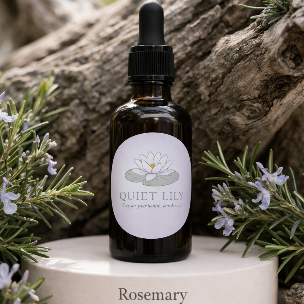 Bottle of Quiet Lily Rosemary Hair & Brow Oil on a white platform with natural background
